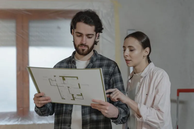 Homeowners going through loft conversion floor plans at home before appointing a designer in Cornwall