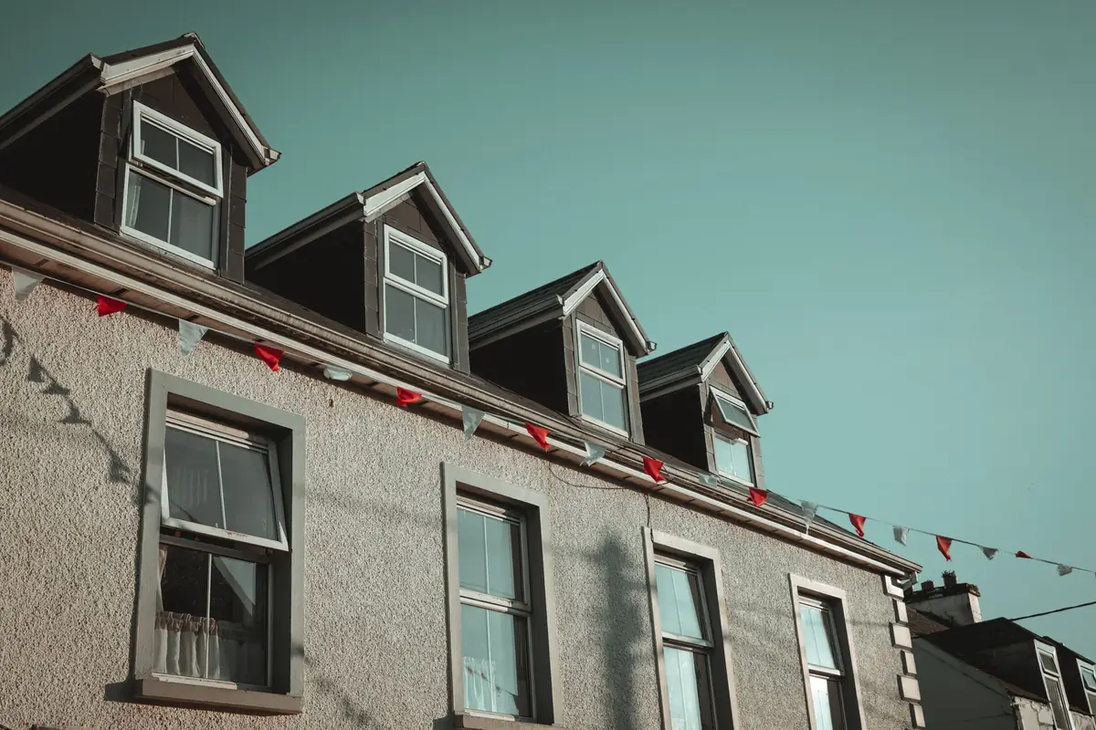 Row of pitched roof dormers on a terrace, the loft conversion type that adds standing height in Cornish homes