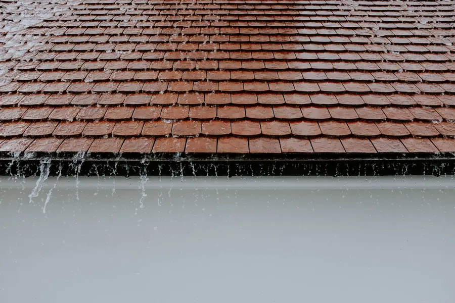 Rain running off a tiled roof, the wind driven wet weather that makes dormer detailing critical in Cornwall