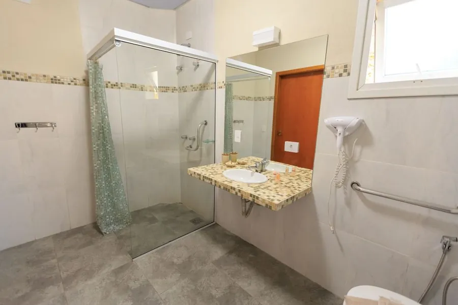 Bathroom fitted with a grab rail beside the shower, the kind of accessible detail built into an elderly relative's annexe