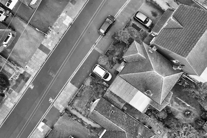 Aerial view looking straight down on a hipped roof semi-detached house beside a residential street, the roof shape most suited to a hip-to-gable loft conversion in Cornwall