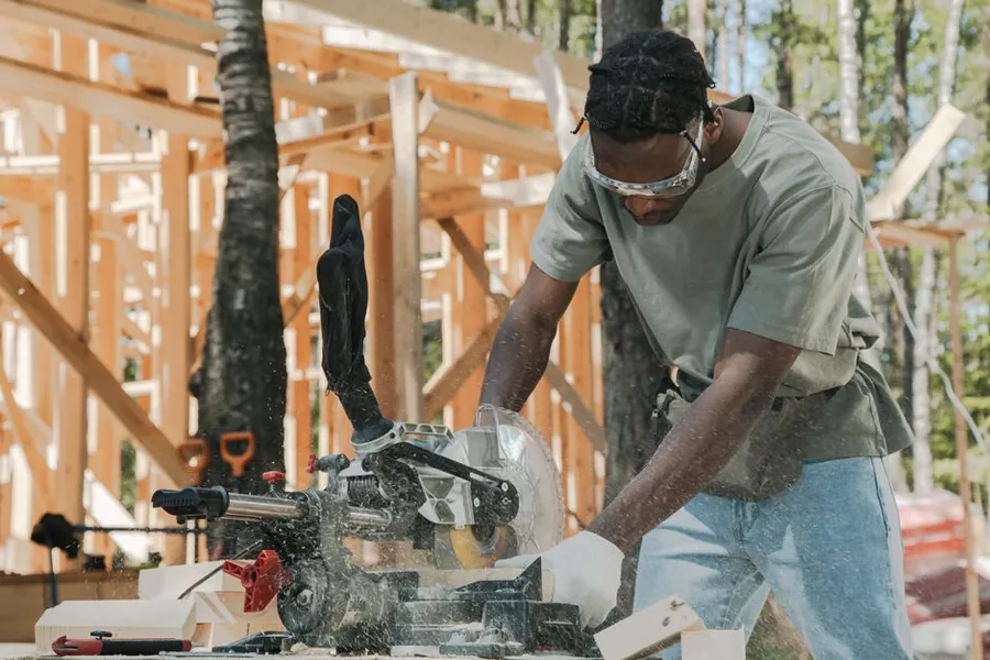 Carpenter cutting timber with a circular saw, the sort of short loud task worth scheduling around calls