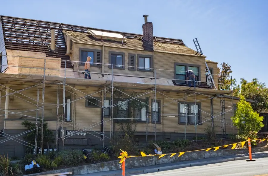 Scaffolding around a house with workers on the roof, the stage that changes light and security for a fortnight