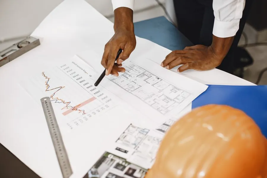 Building professional reviewing floor plans on site, part of the building control process a loft conversion goes through