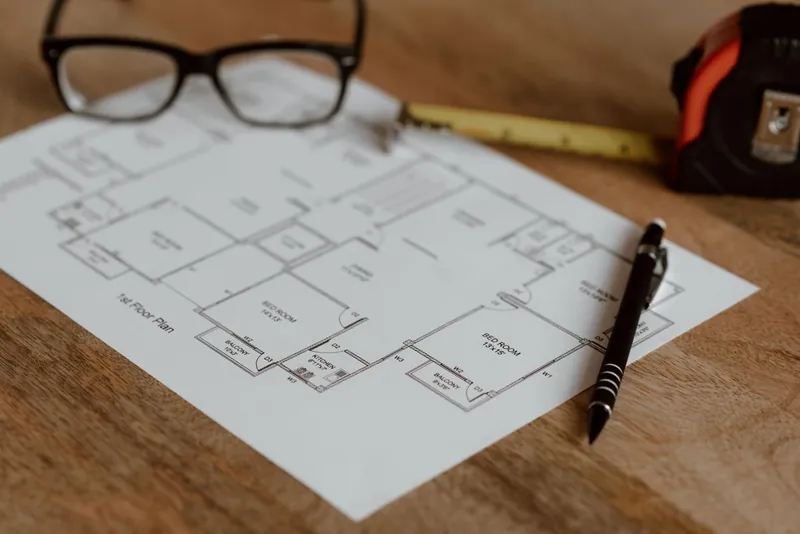 House plans with a ruler and pencil laid out while comparing loft conversion design fees