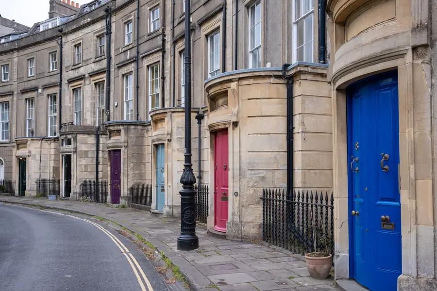 Georgian stone terrace with tall sash windows and painted doors along a curving street, the type of period house found in Truro's conservation area where loft conversions need careful design