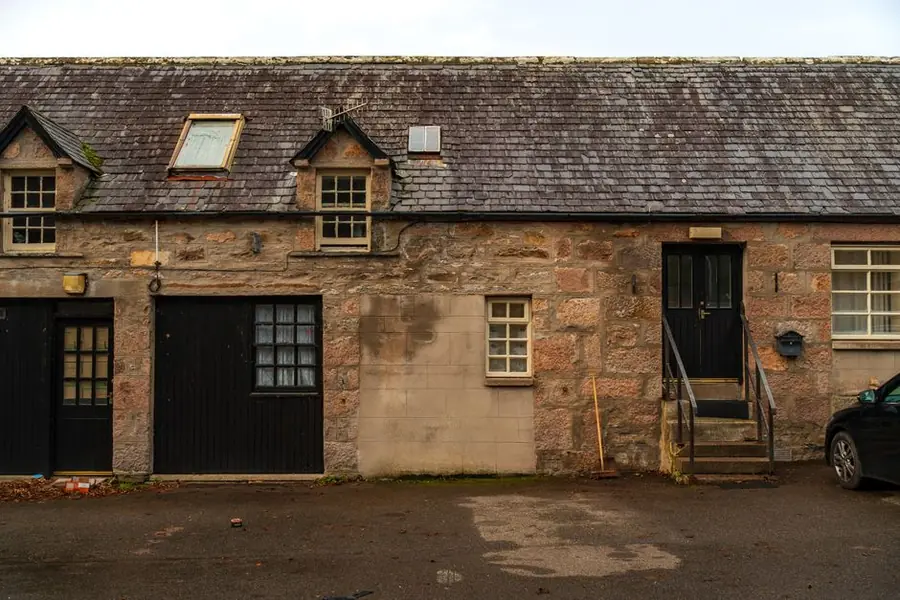 Stone cottage with small dormers and a rooflight in a slate roof, the traditional way of gaining loft headroom on older buildings