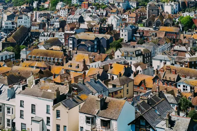 Hillside town rooftops with continuous ridge lines, showing why raising one ridge for loft headroom is a planning question