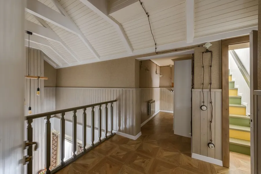 Stair rising to a converted attic under a sloping ceiling, where loft conversion stair headroom has to be checked