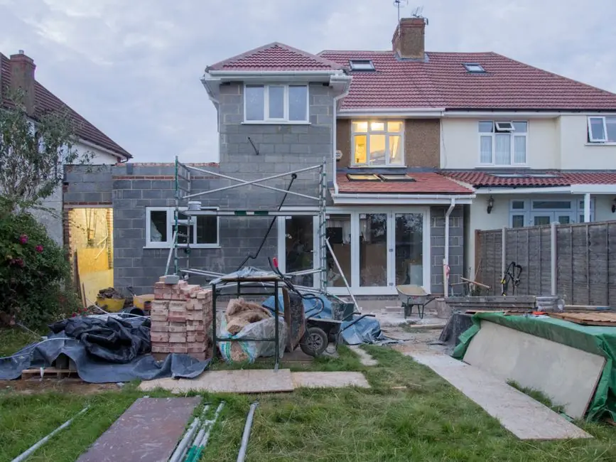 House undergoing major building work with scaffolding, showing the shell costs an extension carries before any room exists