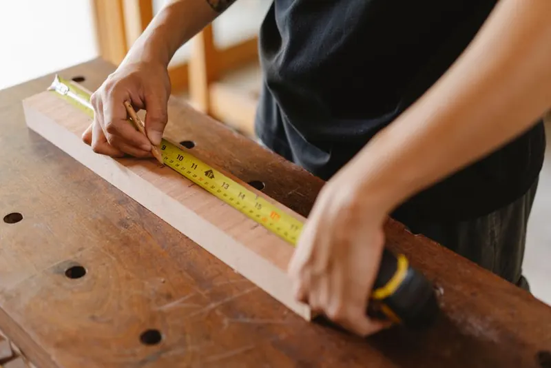 Joiner measuring timber for a new loft conversion staircase in Cornwall