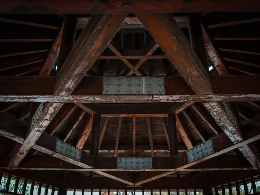 Timber roof truss with diagonal webs and metal connector plates fixed at every joint, the same principle as the trussed rafter roofs that need re-engineering before a loft conversion in Cornwall