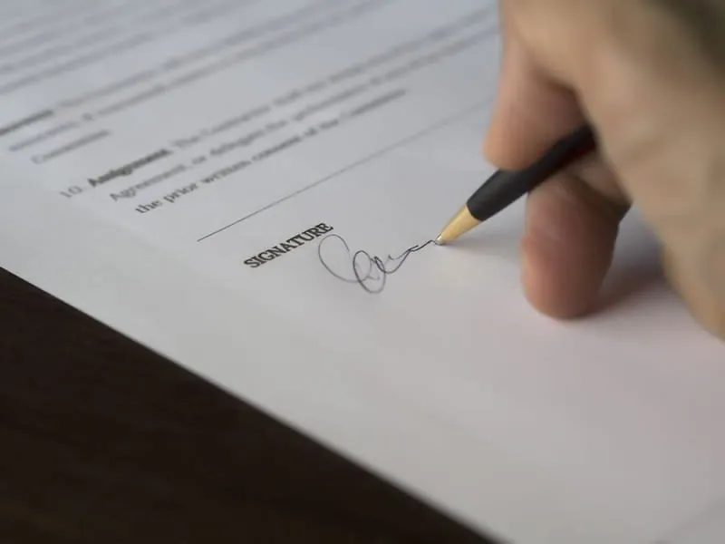 Homeowner signing a written contract for a conversion project