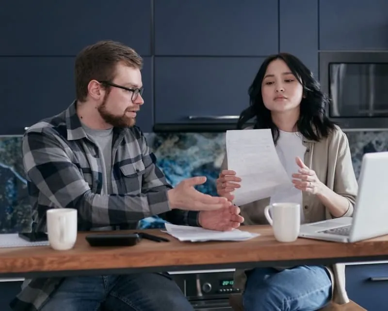 Homeowners going through conversion quotes and plans at a kitchen table