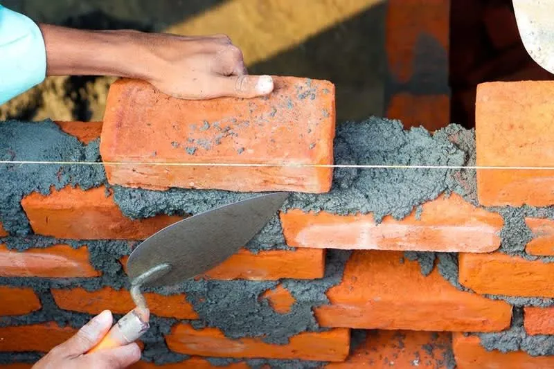 Bricklayer building the infill wall where a garage door opening used to be
