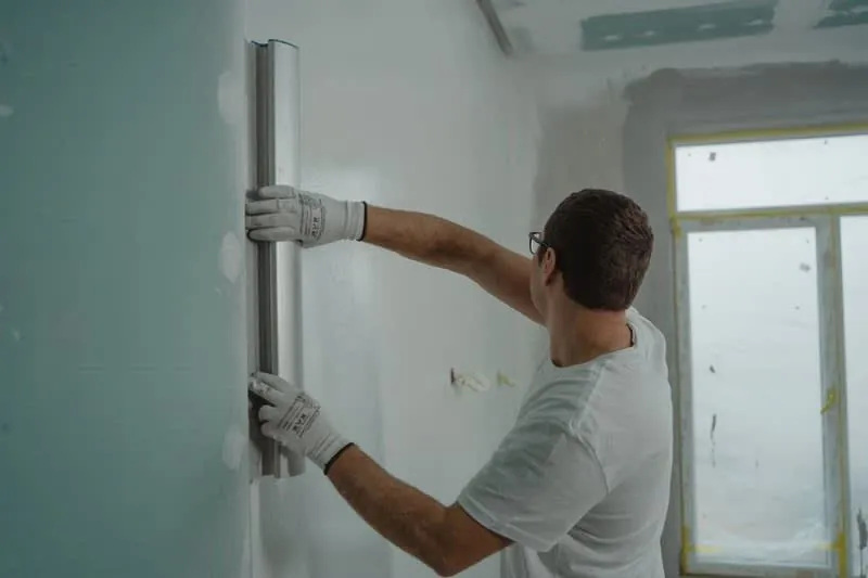 Insulation and lining boards being fixed to the internal wall of a garage conversion