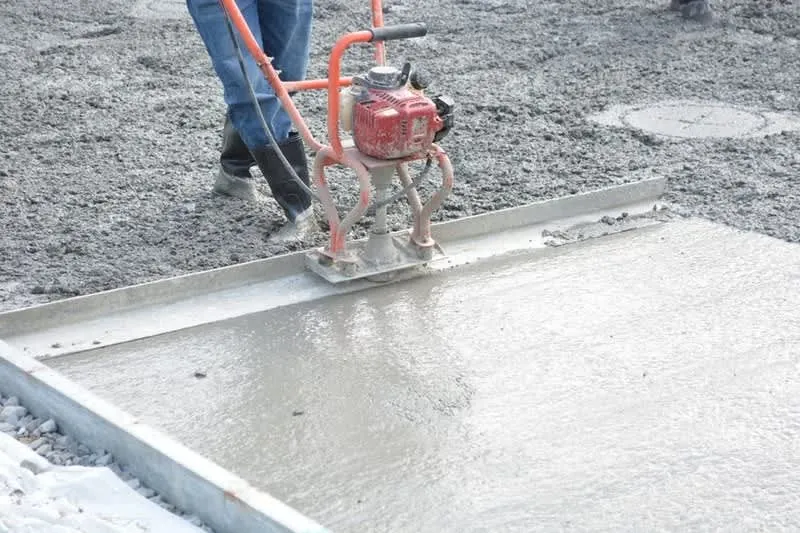 Concrete floor slab being finished, the stage where a damp proof membrane is built into a garage conversion