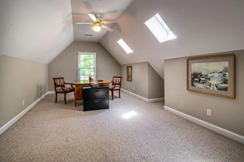 Converted loft room in use as a home office with a roof window
