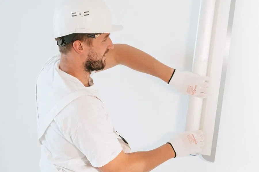 Plasterer skimming a wall to a smooth finish during a conversion fit-out