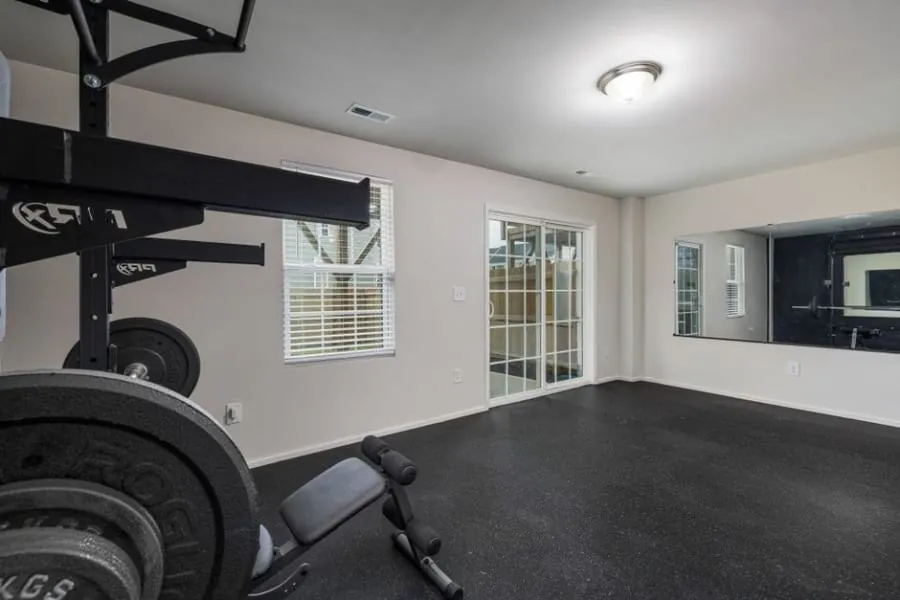 Converted garage in Cornwall fitted out as a home gym with rubber flooring and full-height glazing