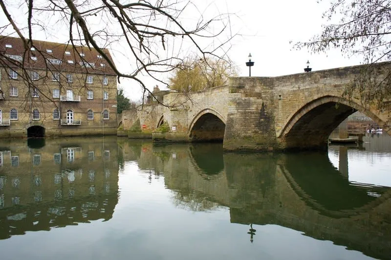 Arched medieval stone bridge crossing a calm river